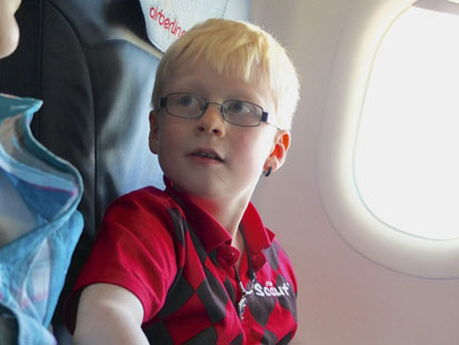 Oliver sitzt im Flugzeug und staunt.